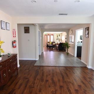 A spacious hallway leading to a living area with wooden flooring and decor.
