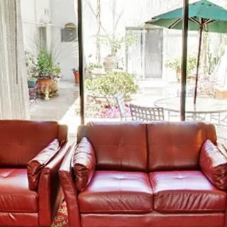 A cozy living area with leather couches and a view of the patio through glass doors.