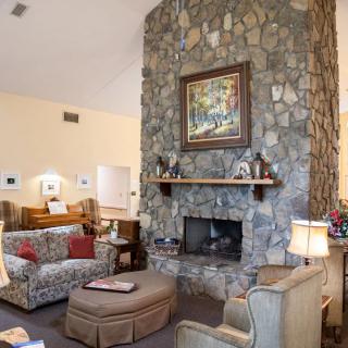 A cozy living room featuring a stone fireplace and comfortable seating.