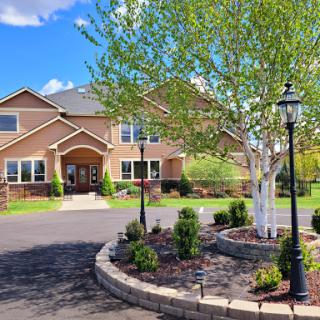 A beautifully landscaped residential building with lush greenery and charming pathways.