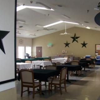 A spacious dining area with tables, chairs, and star-themed decorations.