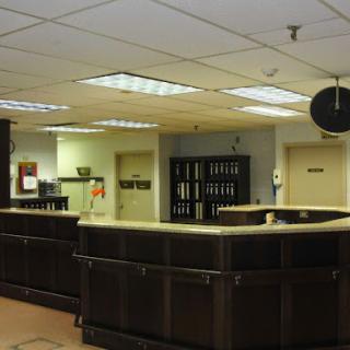 A view of a reception area featuring a dark counter and office environment.