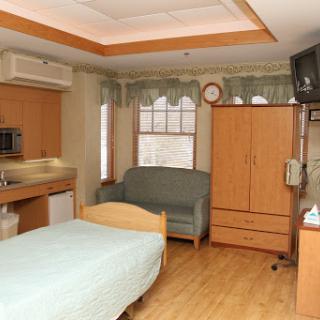 A comfortable hospital room featuring essential furniture for patients.