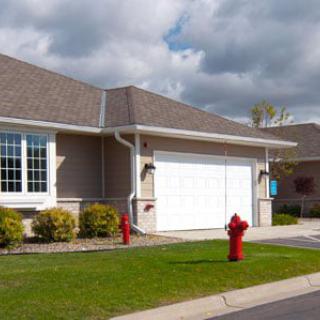 A suburban house with a two-car garage and a red fire hydrant in front.