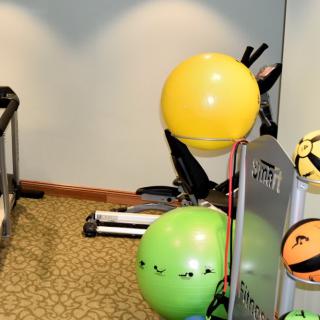 Gym with exercise equipment and colorful emoticon balloons.