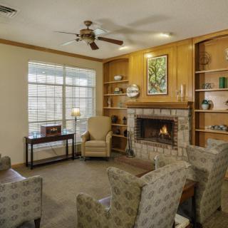 Cozy living room with a fireplace, armchairs, and built-in bookshelves.