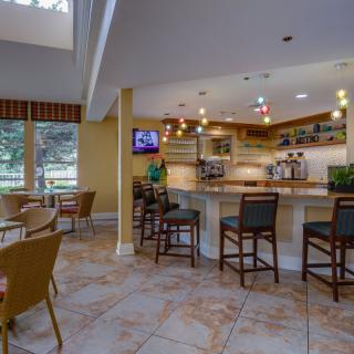 A modern bar interior with a counter, seating, and decorative lighting.