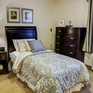A cozy bedroom with neatly arranged furniture and a comfortable bed.
