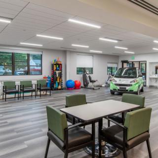 A spacious therapy center with modern equipment and seating areas.
