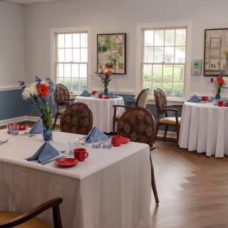 A cozy dining room with elegantly set tables and floral arrangements.