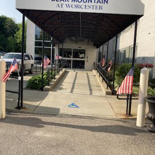 Entrance of the facility with American flags lining the pathway in Worcester.