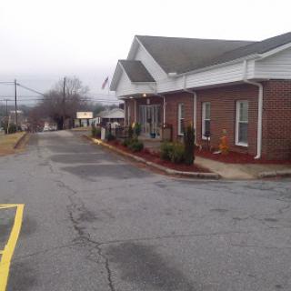 A quiet street scene featuring a brick building and cloudy sky.