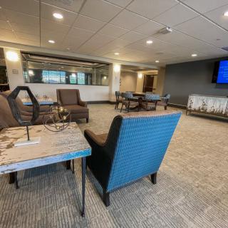 A modern lounge area with comfortable seating and a large television.