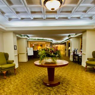 A spacious and inviting lobby featuring comfortable seating and a decorative table with plants.