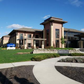 A modern building with a landscaped garden and clear blue sky.