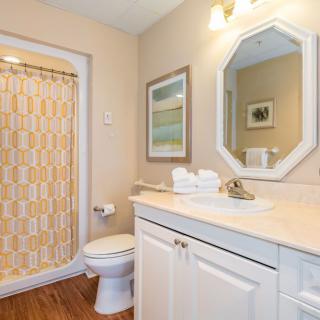 A neatly arranged bathroom with a shower, sink, and toilet.