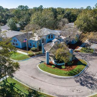 Aerial view of a suburban residential area with blue buildings and surrounding greenery.