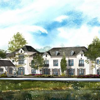 A picturesque view of a large residential building surrounded by trees and greenery under a clear blue sky.