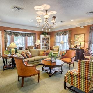 A cozy and traditionally decorated living room featuring elegant furniture and a chandelier.