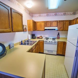 A cozy kitchen with wooden cabinets and standard appliances.