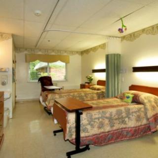 A hospital room with two beds and medical equipment, featuring a calm and organized atmosphere.