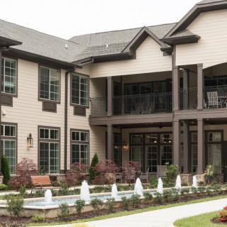 A modern residential building with an outdoor fountain and landscaped garden.