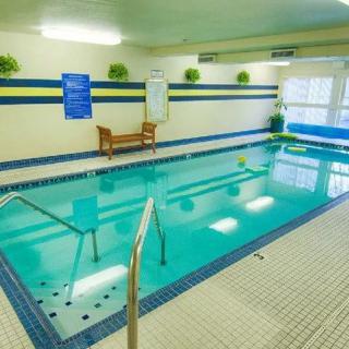 An indoor swimming pool with seating and decor, offering a relaxing atmosphere.