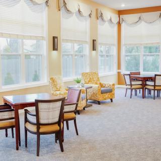 A bright and spacious dining area with tables, chairs, and large windows.