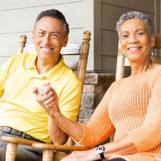 A joyful couple enjoying a relaxing moment together on their porch, sharing smiles and affection.