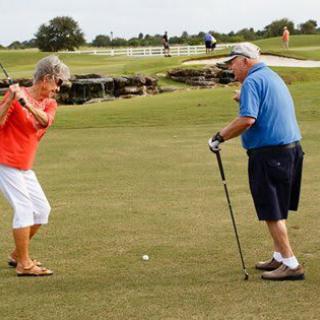 Two seniors enjoying a game of golf on a sunny day.