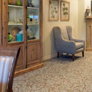 A cozy living room featuring comfortable armchairs and a wooden display cabinet filled with decorative items.