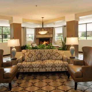 A well-furnished living room with a patterned sofa, armchairs, and decorative lamps.
