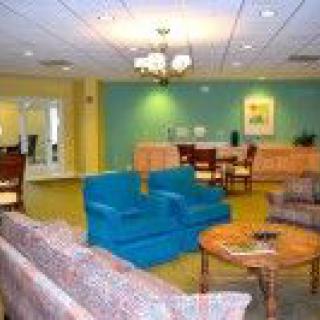 A cozy lounge area with colorful chairs and sofas arranged around a coffee table.