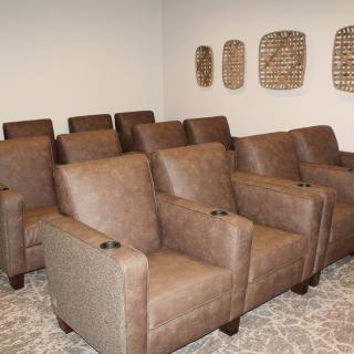 A cozy home theater room with rows of comfortable armchairs.
