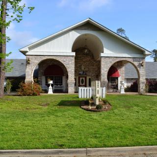 A charming residential building with a landscaped front yard and elegant architectural details.