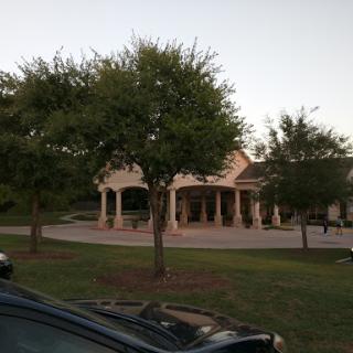 A serene view of a building surrounded by trees during the evening.