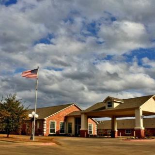 A building with an American flag under a cloudy sky.