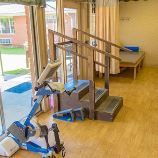 A well-equipped rehabilitation room featuring stairs and exercise equipment.