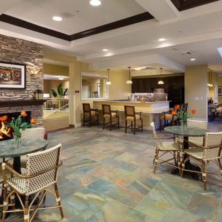 A cozy lobby interior featuring a fireplace, seating area, and bar counter.