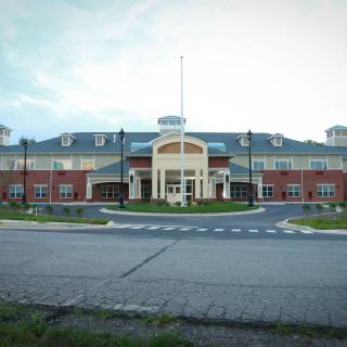 A modern school building with a brick exterior and circular driveway.