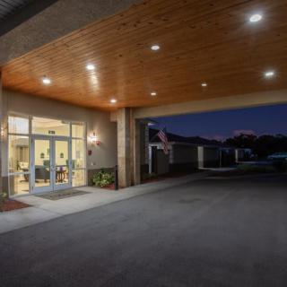 Entrance of a building illuminated at night with overhead lights.