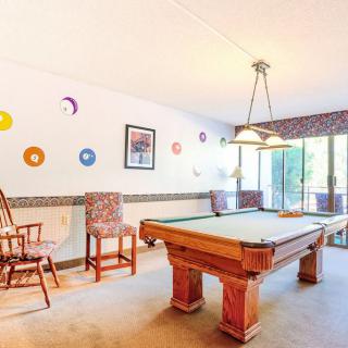 A brightly lit game room with a pool table and colorful wall decor.