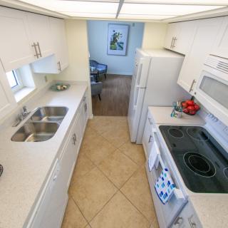 A modern kitchen with white cabinetry and appliances.