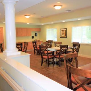 A cozy dining area with several tables and chairs arranged neatly under warm lighting.