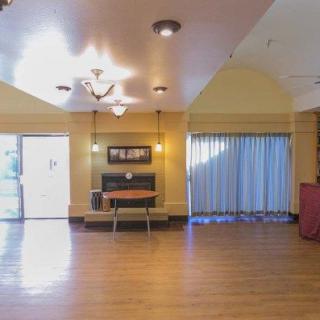 A spacious living room with wooden flooring and elegant lighting.