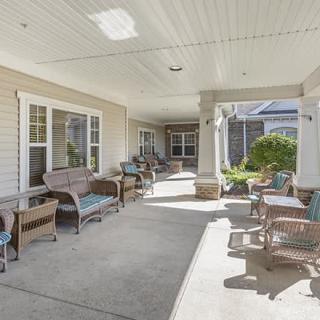 A spacious covered patio with wicker furniture for outdoor relaxation.