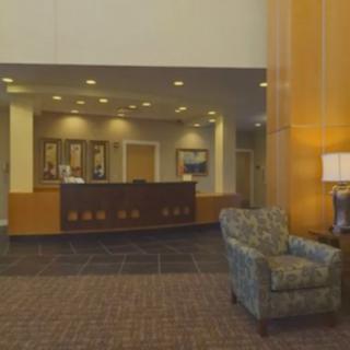 A hotel lobby with a reception desk and comfortable seating.