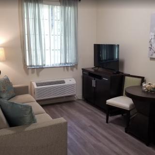 A cozy living room with a sofa, small television, and seating area.