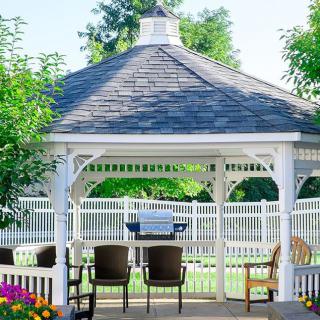 A cozy garden gazebo with chairs arranged for relaxation in a sunny outdoor setting.