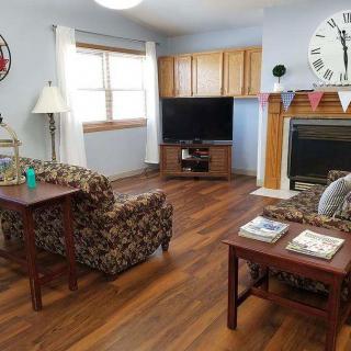 A cozy living room featuring a television, fireplace, and comfortable armchairs.